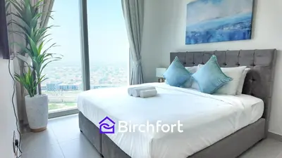 a bedroom with a large bed with a large window at Elegant Flat in Prime Location in Dubai