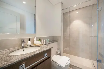 a bathroom with a sink and a glass shower at Trendy 2BR Apartment near Burj Khalifa, Downtown Dubai in Dubai