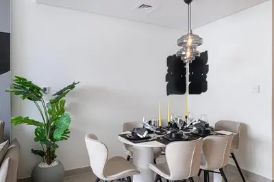 a dining room with a white table and chairs at Trendy 2BR Apartment near Burj Khalifa, Downtown Dubai in Dubai