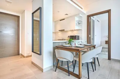 a kitchen and dining room with a wooden table and chairs at STAY BY LATINEM Luxury 2BR Holiday Home OPA 305 Near Downtown in Dubai