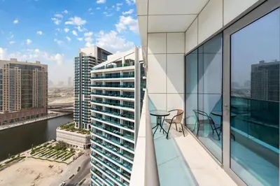 a balcony with a table and chairs on a building at FAM Living - 2BR Apartment with Burj & Canal Views at The Bay in Dubai