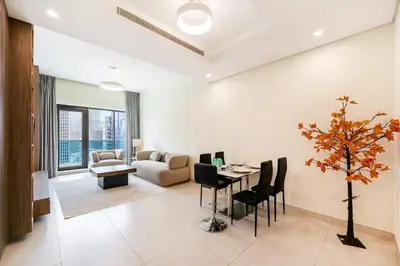 a living room with a table and chairs and a couch at FAM Living - 2BR Apartment with Burj & Canal Views at The Bay in Dubai