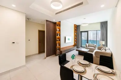 a living room with a table and a couch at FAM Living - 2BR Apartment with Burj & Canal Views at The Bay in Dubai