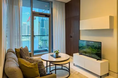a living room with a couch and a tv and a table at Stylish 1B in J one With Balcony & Canal View in Dubai