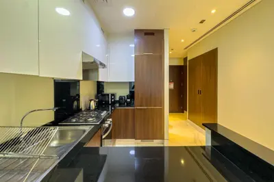 a kitchen with white cabinets and black counter tops at Stylish 1B in J one With Balcony & Canal View in Dubai