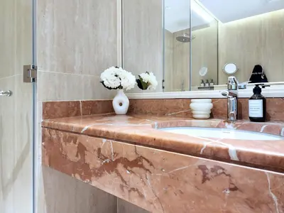 a bathroom with a sink with a vase of flowers at SOLARTE Luxe - New Large 2BR - Marina Promenade - Sea Views - Super King Bed & Workspace in Dubai