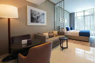 a living room with a couch table and a bed at Cozy Studio in Damac Prive - Free Gym & Pool in Dubai