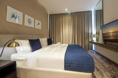 a hotel room with a large bed and a flat screen tv at Cozy Studio in Damac Prive - Free Gym & Pool in Dubai