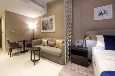 a hotel room with a couch and a bed at Cozy Studio in Damac Prive - Free Gym & Pool in Dubai