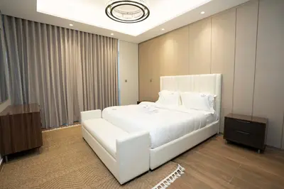 a bedroom with a large white bed with white pillows at Spacious Luxe 2BR in Dubai - With Pool and Gym in Dubai
