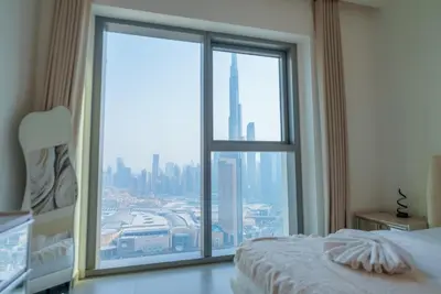 a bedroom with a large window with a city view at Luxury2BR BurjKhalifa View Infinity Pool Mall Walk in Dubai