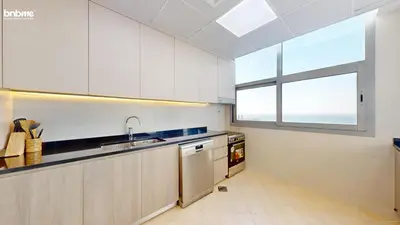 a kitchen with white cabinets and a sink and a window at bnbmehomes - DEC Tower 1 in Dubai