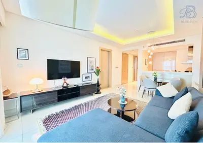 a living room with a blue couch and a tv at 1 Bedroom Apartment in Paramount Tower - A in Dubai
