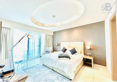a bedroom with a bed and a large window at 1 Bedroom Apartment in Paramount Tower - A in Dubai