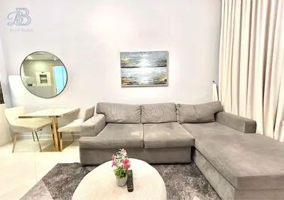 a living room with a couch and a table at 1 Bedroom Apartment in Al Jaddaf - High-Floor with Dubai Skyline View in Dubai