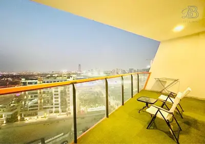 a balcony with a chair and a view of a city at 1 Bedroom Apartment in Al Jaddaf - High-Floor with Dubai Skyline View in Dubai