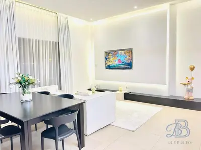 a dining room with a black table and chairs at Stylish 2 Bedroom Apartment in the Heart of JVC - with swimming pool, fully equipped gym, outdoor steam room, kids play area & lots more in Dubai