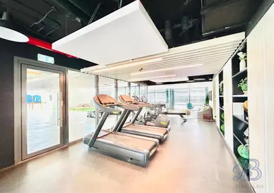 a gym with a row of cardio machines at Stylish 2 Bedroom Apartment in the Heart of JVC - with swimming pool, fully equipped gym, outdoor steam room, kids play area & lots more in Dubai