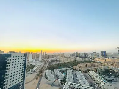 an aerial view of a city with a sunset at Stylish 1 Bedroom Apartment in the Heart of JVC in Dubai