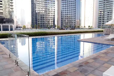 a pool in the middle of a city with tall buildings at 2 Bedroom Apartment with Canal View in Business Bay in Dubai