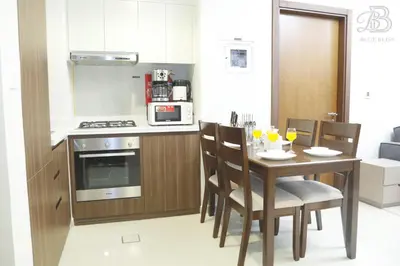 a kitchen with a table with chairs and a microwave at 2 Bedroom Apartment with Canal View in Business Bay in Dubai