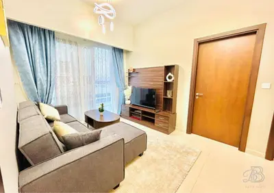 a living room with a couch and a television at 2 Bedroom Apartment with Canal View in Business Bay in Dubai