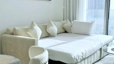 a living room with a couch and a window at Elegant Downtown Escape 1BR w Balcony, Pool & Gym in Dubai
