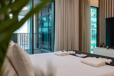 a bedroom with a large white bed with towels on it at Urban Studio - Business Bay in Dubai