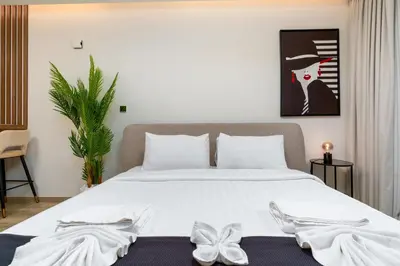 a bedroom with a large bed with white sheets and shoes at Urban Studio - Business Bay in Dubai
