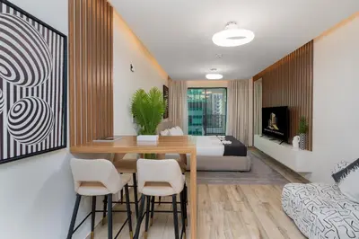 a living room with a dining room table and a bed at Urban Studio - Business Bay in Dubai