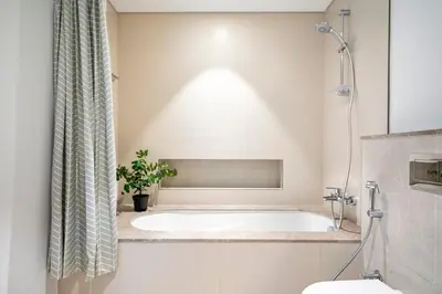 a bathroom with a bath tub and a toilet at The Grand Luxury Residential I1Bedroom I High Floor I Water View I Tennis & Badminton Courts I Rooftop Lounge in Dubai