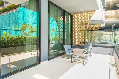 a balcony with two chairs and glass windows at Bookable - 1 Bedroom Binghatti Crescent in Dubai