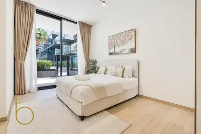 a white bedroom with a bed and a large window at Bookable - 1 Bedroom Binghatti Crescent in Dubai