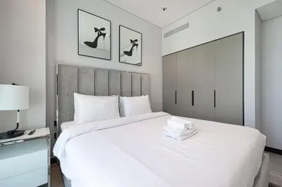 a bedroom with a large white bed with a headboard at 2 Bedroom Apartment in Business Bay Gym, Pool & View in Dubai