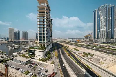 a view of a city with a tall building and freeway at 2 Bedroom Apartment in Business Bay Gym, Pool & View in Dubai