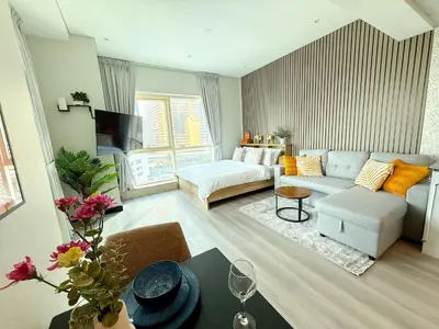 a living room with a couch and a table at Luxury Studio Apartment with large Balcony and Sea Views, free Parking, Dubai Marina - JBR in Dubai
