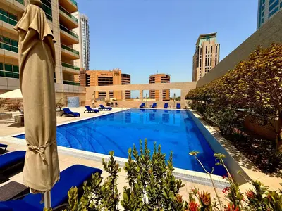 a large swimming pool with chairs and a umbrella at Luxury Studio Apartment with large Balcony and Sea Views, free Parking, Dubai Marina - JBR in Dubai