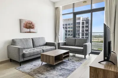 a living room with a couch and a tv at 1BR Azizi Riviera 44 City Skyline View in Dubai
