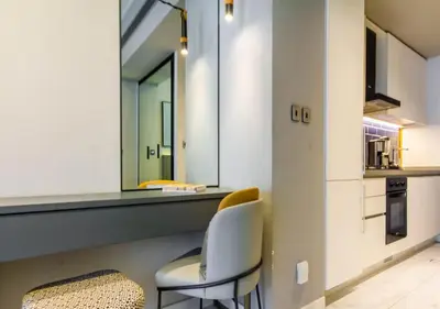 a bathroom with a mirror and a white chair at Stylish Stay, Walk to Dubai Mall, Downtown in Dubai