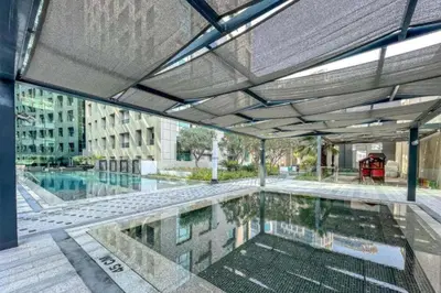 a swimming pool in a building with an open ceiling at City View Studio on High Floor, Steps from Metro, Beside Water Canal, Quick Downtown Access, The Cosmopolitan, Business Bay by Deluxe Holiday Homes in Dubai