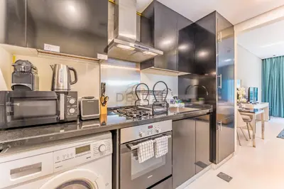a kitchen with stainless steel appliances and a counter top at City View Studio on High Floor, Steps from Metro, Beside Water Canal, Quick Downtown Access, The Cosmopolitan, Business Bay by Deluxe Holiday Homes in Dubai