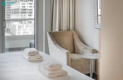 a hotel room with a table and a chair and towels at Blue Breeze - Stunning 1BR with Canal & Pool Views in Dubai