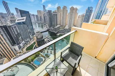 a balcony with two chairs and a view of a city at One Bed Marina View on 34th floor in Dubai