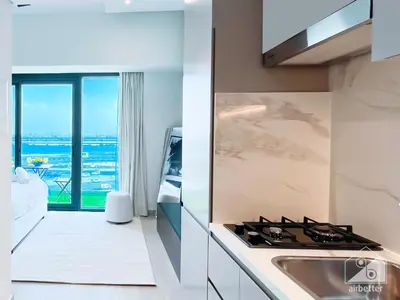 a kitchen with a stove and a view of the ocean at Breathtaking Studio with Balcony & Stunning Views in Dubai