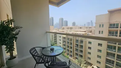 a table and chairs on a balcony with a view at Urban Sunset, Newly Renovated Central 1BR in Dubai