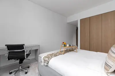 a bedroom with a bed and a desk and a chair at Maison Privee - Sky-High Panoramic Apt with Iconic Burj Khalifa Vws in Dubai