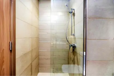 a shower with a glass door in a bathroom at Guest Favorite - Relaxed and Cozy Studio Near Racecourse in Dubai