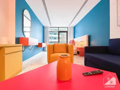 a living room with an orange vase on a table at Colorful Studio with Balcony & City Views in Dubai