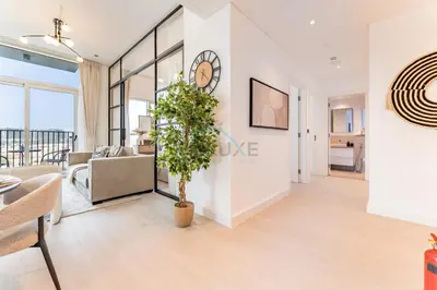a living room with a clock on a wall at Walk to Dubai Hills Mall, Premium Amenities And Near Dubai Hills Park And Golf Club, Socio Tower 1, Dubai Hills by Deluxe Holiday Homes in Dubai