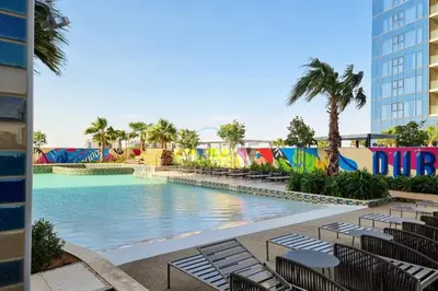 a pool at a resort with chairs and palm trees at Steps from Dubai Water Canal 2BR, Near Safa Park & SZR, Easy Downtown Access, Aykon City 2 Tower C, Business Bay by Deluxe Holiday Homes in Dubai